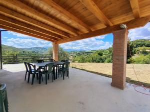 a patio with a table and chairs under a wooden roof at La Casetta di Frank - Country House in Chieti
