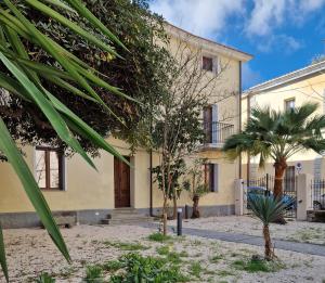 a house with a palm tree in front of it at Casa Sulis Holiday Home in Tortolì