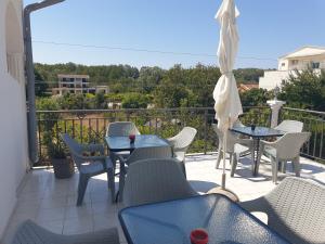 a patio with tables and chairs and an umbrella at House Kraja in Ulcinj +8 photos