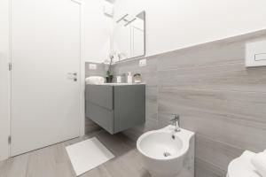 a bathroom with a sink and a toilet and a mirror at Magic Rent - Appartamento Gluck in Milan