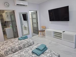 a white living room with a tv and a couch at Casa Tartago in Triana