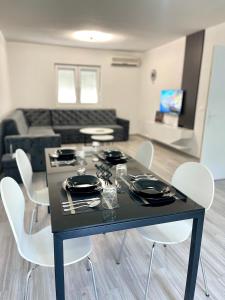 a black table with white chairs in a living room at Neretva House in Blagaj