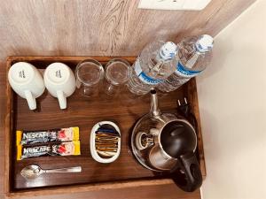a tray with drinking glasses and a tea kettle at Yarsa Appartment in Kathmandu