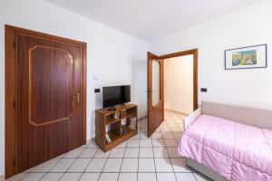 ein kleines Schlafzimmer mit einem Bett und einem Fernseher in der Unterkunft Casa vacanze Casalena 