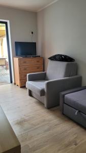 a living room with a couch and a tv at Alina SPAnie in Niechorze +2 photos