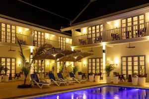 a hotel with a swimming pool at night at Viriya Hotel in Luang Prabang
