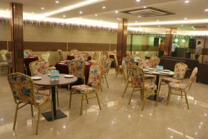 a restaurant with tables and chairs in a room at The Royal casa in Ghaziabad