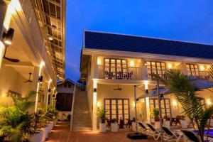 a building with a courtyard with chairs and plants at Viriya Hotel in Luang Prabang