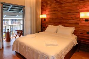 a bedroom with a white bed with a wooden wall at Viriya Hotel in Luang Prabang +44 photos