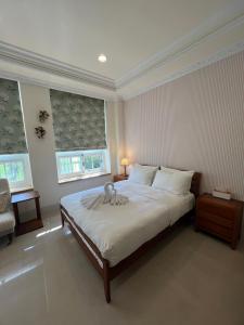 a bedroom with a large white bed with two windows at 屋子旅店 in Puli