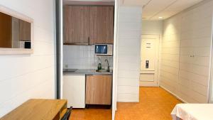 a kitchen with white walls and wooden cabinets at Pension Casa 400 in Vitoria-Gasteiz