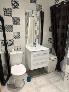 a bathroom with a toilet and a sink and a mirror at Le Lotus Oasis des Pins avec piscine in Labenne