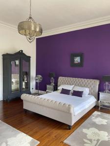 a bedroom with purple walls and a large bed at Chateau de Minargent in Aulnay