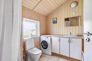 a bathroom with a toilet and a sink and a washing machine at 6840-Allinge-Gjedelokken-23 in Allinge