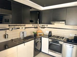a kitchen with black and white cabinets and a dishwasher at Modern Penthouse Overlooking Pool in Pyla