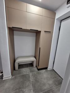 un vestidor con un banco en una habitación en Ssalamandra home's, en Ocna-Mureşului 1 foto más