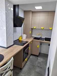 Una pequeña cocina con acentos amarillos en la pared. en Ssalamandra home's, en Ocna-Mureşului
