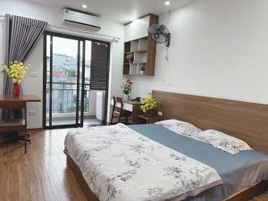 a bedroom with a bed and a desk and a window at Sông Tranh 402MD in Hanoi