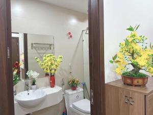 a bathroom with a sink and a toilet and flowers at Sông Tranh 402MD in Hanoi +42 photos