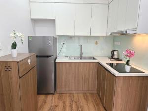 a kitchen with a stainless steel refrigerator and wooden cabinets at Sông Tranh 402MD in Hanoi