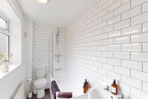 a white bathroom with a sink and a toilet at Sunderland Cosy Cottage in Sunderland +6 photos