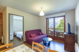 a living room with a purple couch and a balcony at Le Balcon de Barèges - Vue Montagne in Barèges