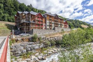 a building on the side of a mountain with a river at Le Balcon de Barèges - Vue Montagne in Barèges +6 photos