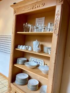 a wooden hutch with plates and dishes in it at Wohnung im Landhaus - Natur mit Balkon & Garten in Trösel +20 photos