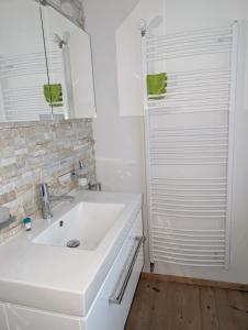 a white bathroom with a sink and a shower at Wunderschöne 3 Zimmerwohnung mit Bergblick in Celerina in Celerina