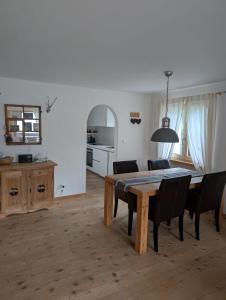 a dining room with a table and chairs and a kitchen at Wunderschöne 3 Zimmerwohnung mit Bergblick in Celerina in Celerina