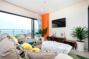 ein Wohnzimmer mit Sofa und Tisch in der Unterkunft Aria Resort Vũng Tàu - Căn Hộ & Biệt Thự Nghỉ Dưỡng Có Bãi Biển Riêng Rất Lý Tưởng Cho Gia Đình in Xã Thắng Nhứt