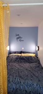 a bedroom with a bed with a sign on the wall at Bleu - 3 star small gite with hot tub and heated pool in Mantilly