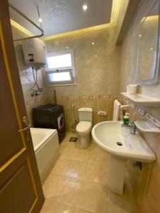 Un baño con lavabo, inodoro y bañera. en Alrehab Cheapest and awesome, en Burg el-Ḥudûd