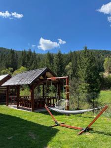 a playground with a gazebo and a slide at Cabana Acasa la Delia in Gîrda de Sus