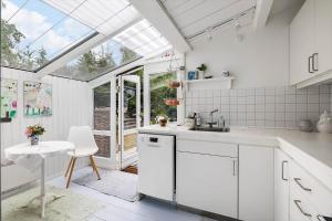 a kitchen with white cabinets and a window at 2724-Nexo-Pilegardsvejen-3 in Neksø