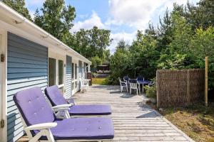 a deck with purple chairs and tables on a house at 2724-Nexo-Pilegardsvejen-3 in Neksø