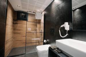 a bathroom with a toilet and a sink and a shower at Marlen Residence Hotel in Eskiömerler