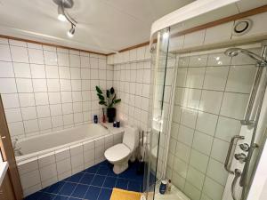 a bathroom with a tub and a toilet and a shower at Cozy Landscape House, Near pulpit Rock in Strand +32 photos