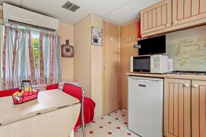 Una pequeña cocina con una mesa y un microondas. en Cocoon, en Sainte-Croix-du-Verdon