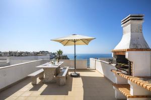 a balcony with a table and an umbrella at Casa Carvoeiro Bay J in Carvoeiro