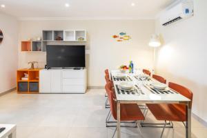 a dining room with a table with chairs and a tv at Casa Carvoeiro Bay J in Carvoeiro