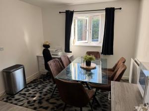 a dining room with a glass table and chairs at 14 Lumb close in Swindon +28 photos