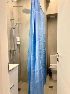 a bathroom with a shower with a blue shower curtain at Family Luxury Suite by Zeus Suites in Athens