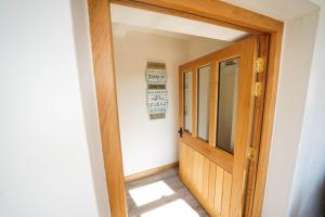a hallway with a wooden door in a room at Honeysuckle Cottage in Hele
