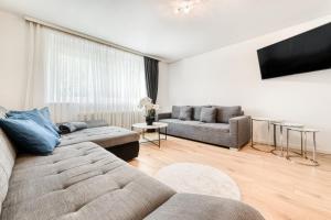 a living room with two couches and a flat screen tv at Gartenferienwohnung Arlberg in Braz