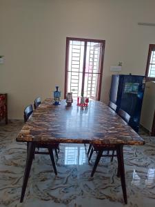 a large wooden table in a room with chairs at Sacred Arunachala View Homestay and Rooms in Tiruvannāmalai