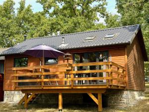 a large deck with an umbrella on a cabin at South Soul Cottage in Somme-Leuze
