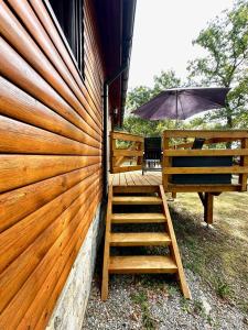 a wooden deck with a ladder and an umbrella at South Soul Cottage in Somme-Leuze