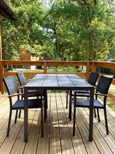 a wooden table and chairs on a deck at South Soul Cottage in Somme-Leuze