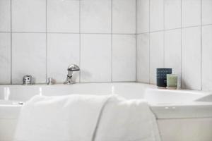 Un baño blanco con bañera y lavabo. en OH156-Hadsund-Halvrebene-26, en Hadsund